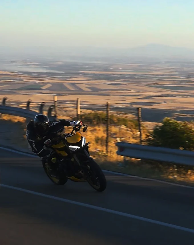 Shadow — la moto in piega nella curva, con la pianura sullo sfondo